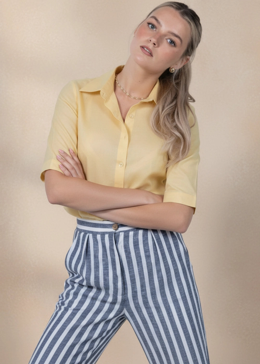 Woman wearing yellow linen–cotton slim-fit shirt with roll-up sleeves.