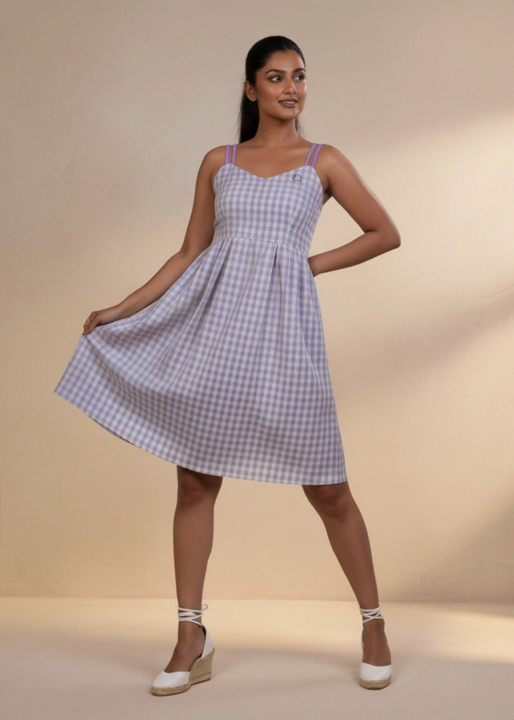 Woman in lavender gingham sundress with sweetheart neckline and pleated skirt.